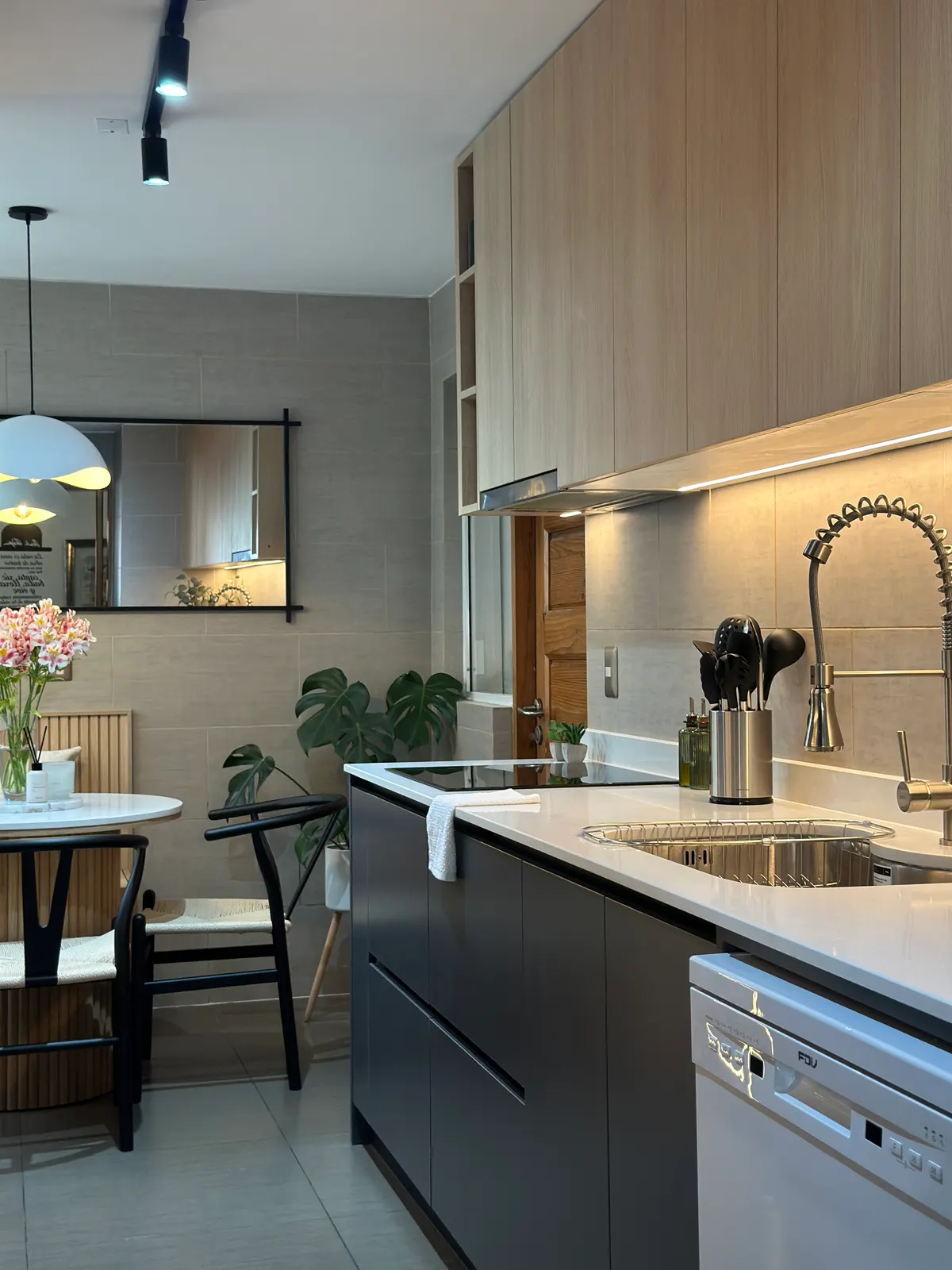 Cocina lineal en grafito con muebles altos de roble y el comedor al fondo