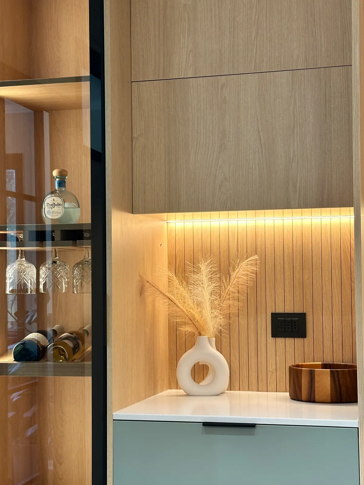 Vitrina con cristalería y accesorios, iluminada desde adentro