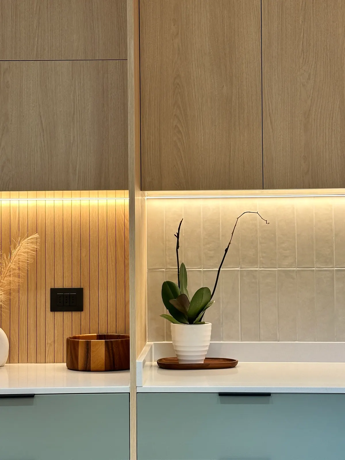 Nicho de roble con luz cálida y muebles bajos en verde salvia